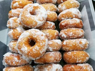 Kuih keria keledek oren bersalut gula putih, tersusun atas pinggan