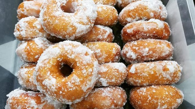 Kuih keria keledek oren bersalut gula putih, tersusun atas pinggan