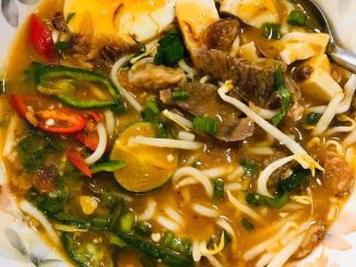 Semangkuk mee rebus utara dengan kuah pekat, telur rebus, cili, taugeh dan taburan daun sup
