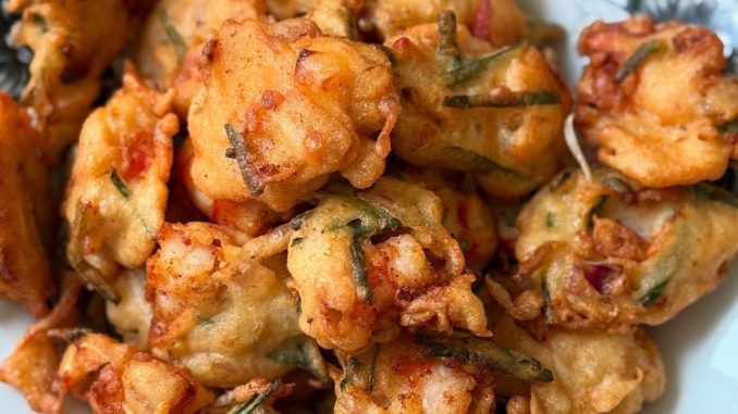 Cucur udang rangup berisi udang, kucai dan kentang goreng keemasan atas pinggan