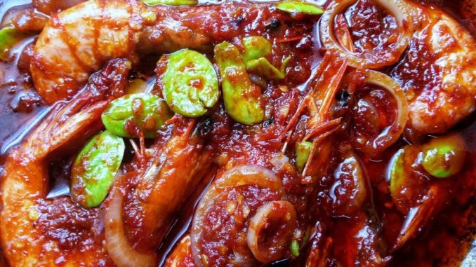 Sambal udang goreng petai berwarna merah pekat dalam pinggan hidangan