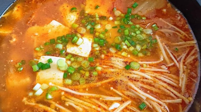 Semangkuk Kimchi Jjigae versi Melayu dengan ayam, tauhu lembut, telur, cendawan enoki dan daun bawang