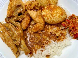 Gulai ayam Terengganu dengan kuah pekat dalam mangkuk, disusun bersama nasi minyak dan ulam