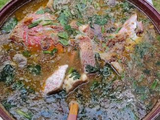 Sup ikan merah hijau pedas dengan daun sup dan bawang goreng