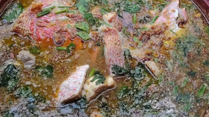 Sup ikan merah hijau pedas dengan daun sup dan bawang goreng