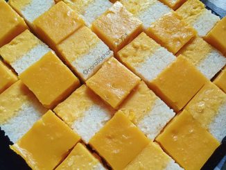 Kuih serimuka jagung lapisan kuning lembut di atas pulut putih dalam loyang segi empat