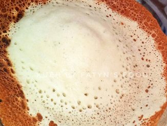 Kuih apom lenggang tradisional yang bertekstur lembut dan rangup di tepi, disusun atas pinggan putih