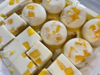 Puding mangga dua lapisan dalam acuan lompang, berwarna putih dan oren dengan topping buah mangga