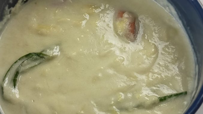 Kuah durian pekat berlemak dalam mangkuk bersama daun pandan, siap untuk dihidang dengan lempeng