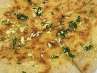 Roti naan cheese homemade disapu garlic butter dan dipotong segi tiga atas pinggan putih