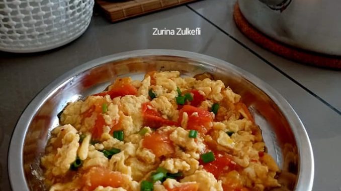 Hidangan telur masak tomato gaya Cina tanpa bawang, dengan daun bawang dan kuah berwarna merah