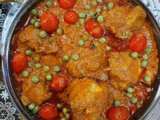 Ayam Masak Ros Mamak berkuah pekat merah, dihias dengan daun ketumbar dan tomato