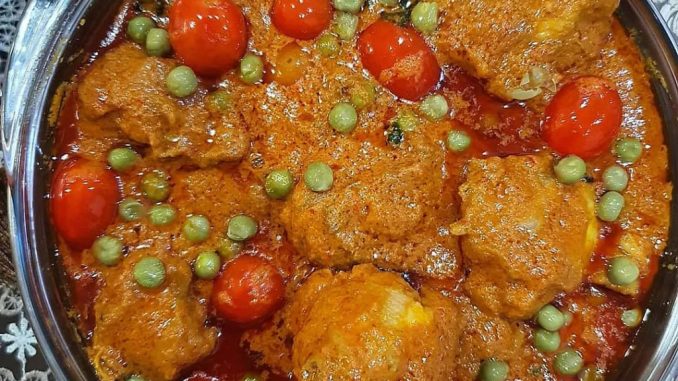 Ayam Masak Ros Mamak berkuah pekat merah, dihias dengan daun ketumbar dan tomato