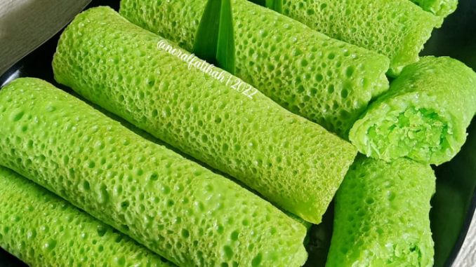Kuih ketayap inti pandan bergulung kemas dengan kulit hijau berlubang halus dan inti kelapa manis