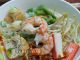 Semangkuk white mee curry Penang dengan kuah putih santan, sambal cili dan isi makanan laut