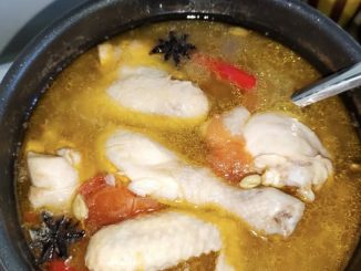 Sup ayam sedap dan mudah dengan tomato segar dan cili padi dalam mangkuk putih