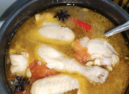 Sup ayam sedap dan mudah dengan tomato segar dan cili padi dalam mangkuk putih