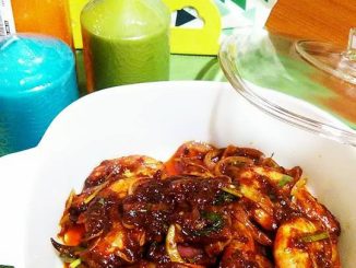 Udang berempah sweet sour dalam pinggan, kuah merah pekat dengan bawang dan daun sup