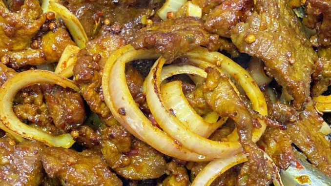 Daging goreng ketumbar dengan bawang besar dan telur mata kicap atas nasi putih panas