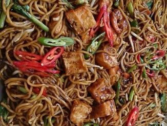 Mee goreng basah dengan udang, sawi, tauhu dan kuah padu dalam pinggan hidangan