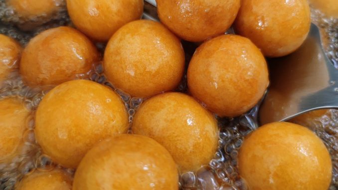 Bebola keledek manis digoreng kuning keemasan, disusun dalam pinggan