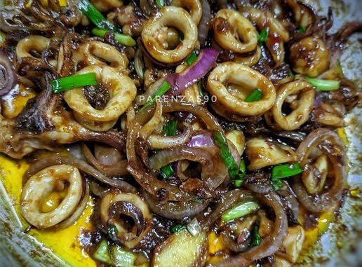 Sotong goreng kicap butter dalam kuali bersama bawang dan cili