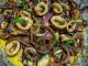 Sotong goreng kicap butter dalam kuali bersama bawang dan cili