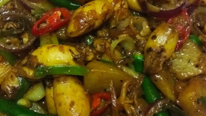 "Hidangan sotong goreng lada bersama ubi kentang goreng dan hirisan cili padi dalam pinggan putih"