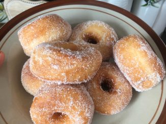 Donat gebu dan keemasan yang tidak serap minyak disusun dalam pinggan putih