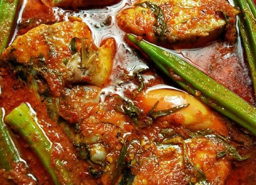 Ikan tenggiri masak asam pedas Johor dengan kuah merah pekat, daun kesum dan bunga kantan