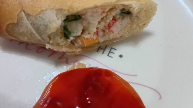 Popia crab rangoon yang rangup keemasan disusun kemas di atas pinggan putih.