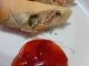 Popia crab rangoon yang rangup keemasan disusun kemas di atas pinggan putih.
