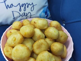 Cekodok jagung keemasan tersusun di atas pinggan, kelihatan rangup dan berkilat, sesuai untuk minum petang.