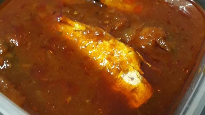 Ikan sardin segar dimasak dalam kuah tomato pekat dalam periuk pressure cooker