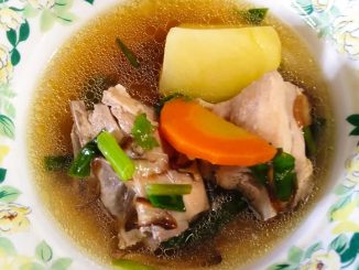 Sup ayam tumis darat pedas dengan kentang, lobak merah, cili api dan taburan daun sup, dihidang panas dalam mangkuk