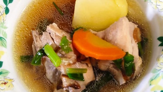 Sup ayam tumis darat pedas dengan kentang, lobak merah, cili api dan taburan daun sup, dihidang panas dalam mangkuk