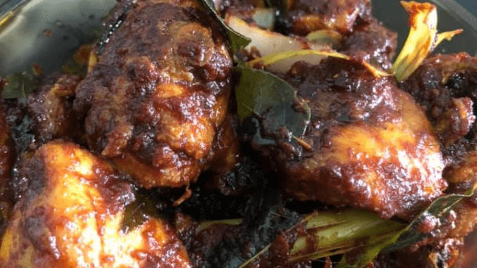 Ayam Masak Bali berkuah pekat pedas manis, dihias dengan bawang hiris dan daun kari.
