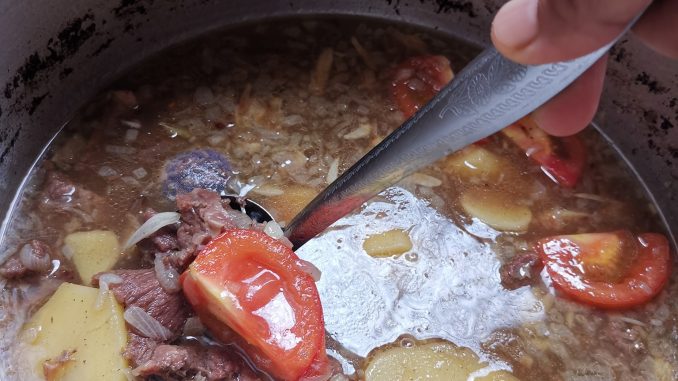 Tumis bawang, halia dan serai untuk sup daging Thai dalam kuali
