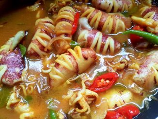 Sotong masak asam dengan warna kuah pekat dan aromatik, dimasak dengan daun kari dan air asam jawa, siap untuk dimakan dengan nasi panas.