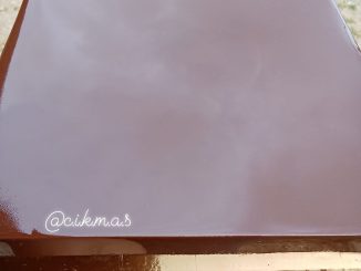 Puding coklat berkilat dan sejernih kaca disusun cantik atas pinggan putih, dihias dengan parutan coklat.