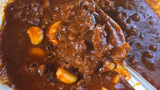 Daging goreng merah Terengganu dengan kuah pekat berkilat, ditabur bawang hiris, dihidang bersama nasi putih panas.