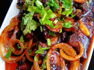 Daging masak merah ala Thai dengan bawang besar dan cili padi, disajikan panas.