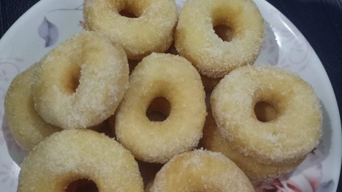 Donut gebu buatan sendiri yang berwarna keemasan, disusun cantik dalam pinggan.