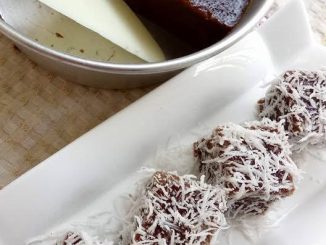 Kuih kaswi kukus berwarna perang dengan taburan kelapa parut di atas, disusun cantik untuk hidangan minum petang.