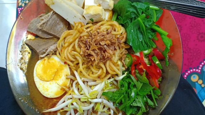 Mee Jawa siap hidang dengan telur rebus, tauhu goreng, fishcake dan taburan bawang goreng, daun sup dan cili hiris.