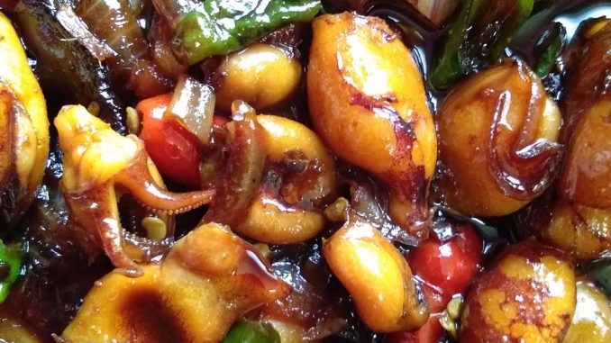 Sotong Masak Kicap Cili Api yang pedas, berwarna gelap dengan hirisan bawang besar dihidang bersama nasi putih.