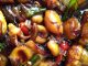 Sotong Masak Kicap Cili Api yang pedas, berwarna gelap dengan hirisan bawang besar dihidang bersama nasi putih.