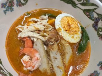 Mee udang simple dihidangkan dengan kuah pekat berwarna merah, udang segar, mi kuning, kangkung, fish cake dan telur rebus.
