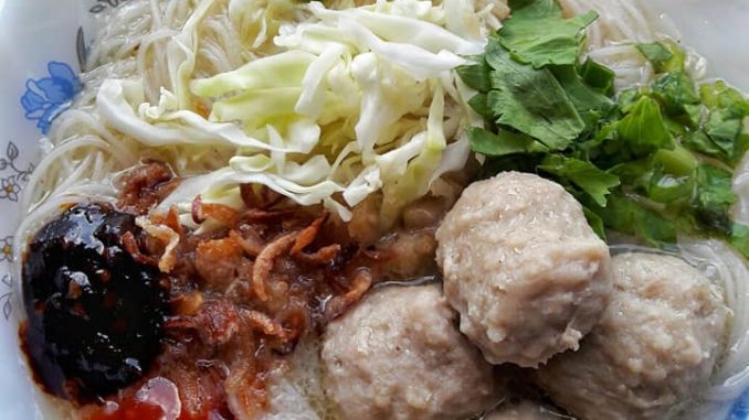 Bihun bakso dihidangkan panas dengan kubis, daun sup dan bawang goreng