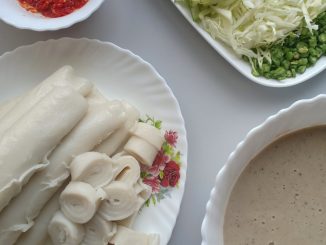 Laksam Kelantan tradisional digulung lembut dan dihidangkan bersama kuah lemak ikan pekat, sambal jantan serta ulam-ulaman segar.